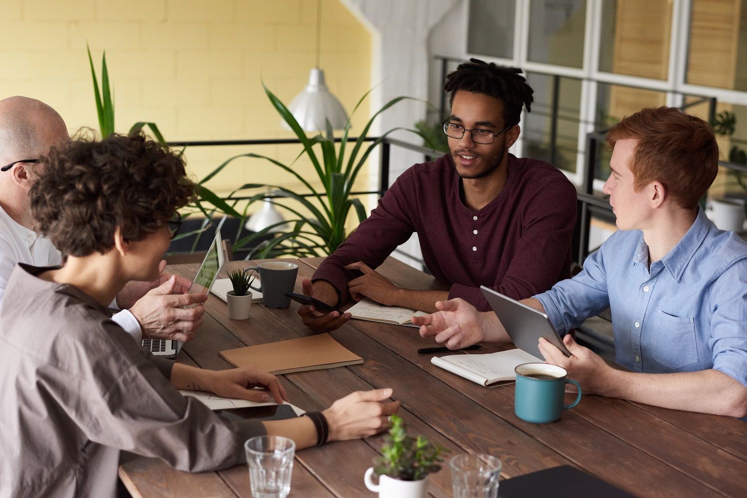 Photo Of People Leaning On Wooden Table 3184585